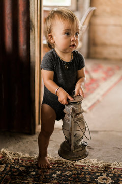 A baby holding an old lantern