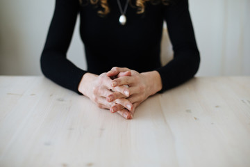 woman sitting with hands folded