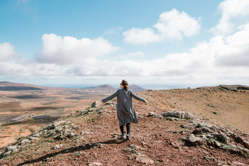 Woman in coat standing in picturesque valley