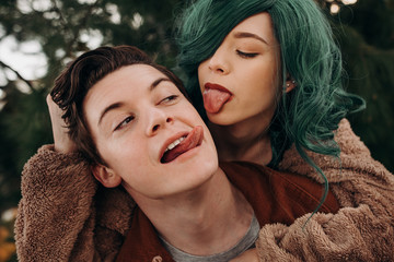 Cute young couple being playing sticking out their tongues