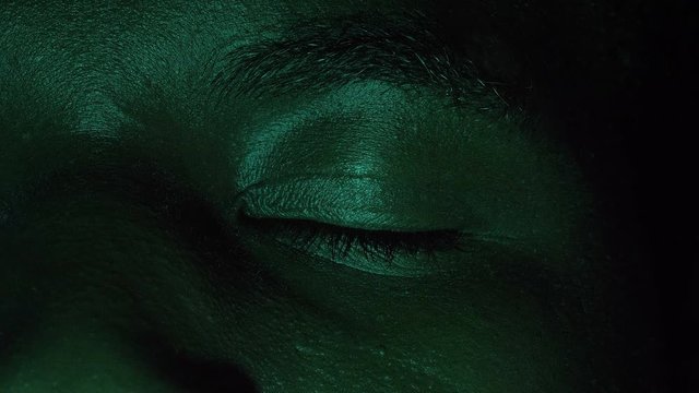 scared young black african man opening his eyes in the dark