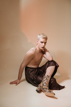 Fashionable gay man in boots and skirt