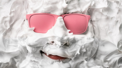 Portrait of a man with shaving foam and pink glasses