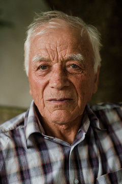 Old man with gray hair looking at camera