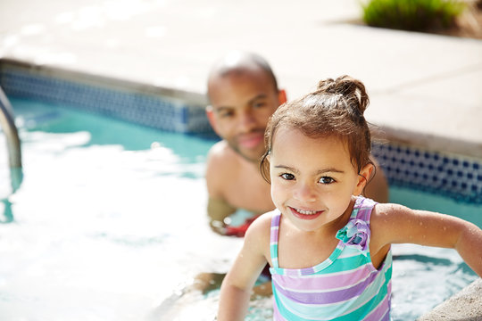 Portrait of an adorable young girl swimming with her father