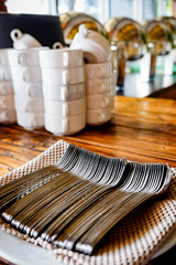 Buffet Utensil Set in Neat and Tidy Arrangement on Vintage Wooden Table in a Restaurant or Cafe