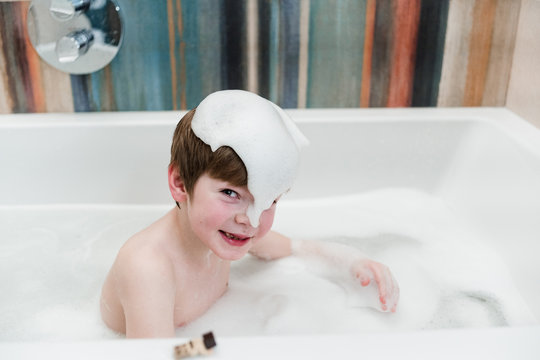 Little caucasian boy washes in the bath