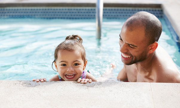 Ethnic Father Helping His Young Daughter Learn To Swim