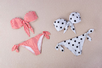 red and white striped sita bikini and black and white polka dot bikini isolated on textured...
