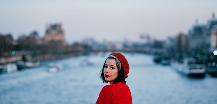 young woman dressed in red contemplating the river Sena