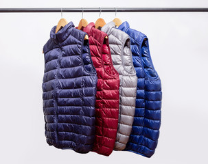 family concept or showroom of down vest jackets hanging on a hanger in the wardrobe © oleg_ermak