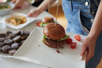 Young woman serving a burger.