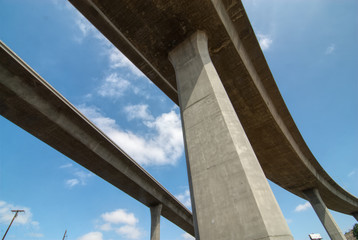 Tall concrete columns supporting freeway traffic ramps and connectors.