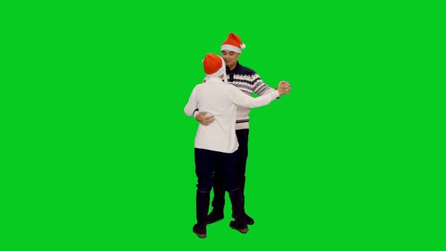 Happy Married Adult Couple Dancing In Santa Hats And Kissing At Christmas On Green Screen