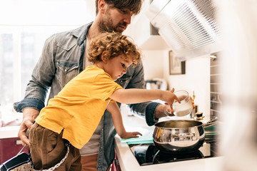 Man with his little cute boy are cooking