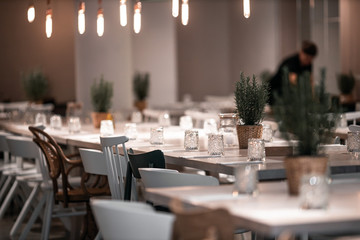 beautifully laid tables with glasses and appliances at night in restauran with blur background