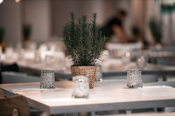 beautifully laid tables with glasses and appliances at night in restauran with blur background