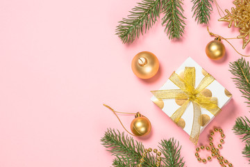 Golden Christmas flat lay background on pink with present box and decorations.