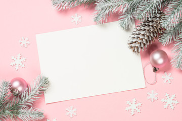 Naklejka na ściany i meble Christmas greeting card with empty blank sheet, fir tree and decorations on pink.