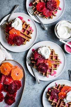 Fluffy and crispy chamomile waffles made gluten-free with oat, sweet rice, and tapioca flours. Drizzled with hot pink blood orange glaze and topped with festive orange supremes and whipped cream