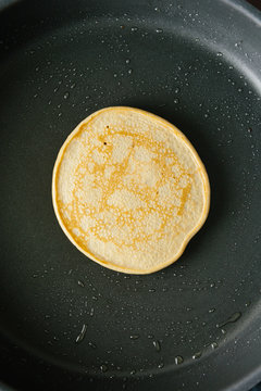 Vegan pancake cooking in a pan overhead