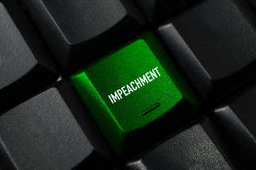 Impeachment concept: a green key on a black computer keyboard with the word impeachment