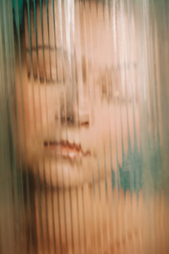 Daydreaming young woman closeup portrait behind the glass with lines