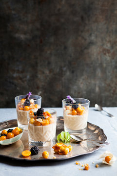 Panna cotta infused with a liquor and topped with blackberries, lavender flowers and gooseberries