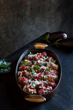 Stuffed eggplant garnished with grated cheese and fresh basil