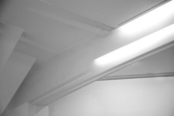 Glowing girders under ceiling. Abstract architecture fragment. Modern office building interior with white polygonal concrete structure. Diagonal geometric composition, Construction in gray halftones.