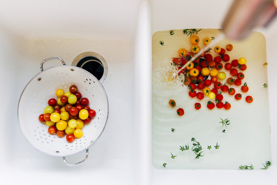 little tomatoes being washed in a sink