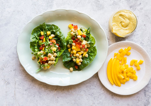 Lettace cups filled with mango chickpea salad and curry tahini