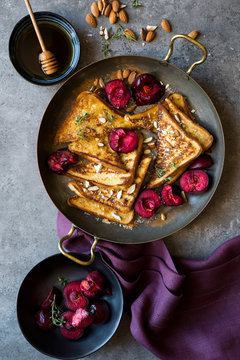 Delicious french toast with roasted plums and maple syrup