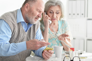 Ill senior couple at home calling doctor