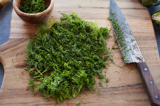 Chopped fresh herbs on a wood cutting board