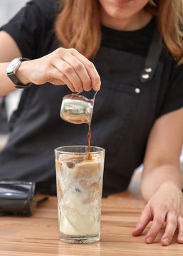 Barista make coffee frappe from milk, ice and espresso. Woman ha