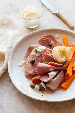 Meat dish of Corned Beef served with roasted carrots, onions and caper berries