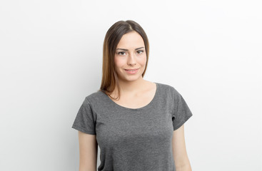 Portrait of a pretty young woman on a white background. Smiling friendly brunette girl.