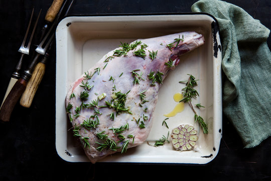 Preparing a meat roast leg of lamb with herbs and garlic