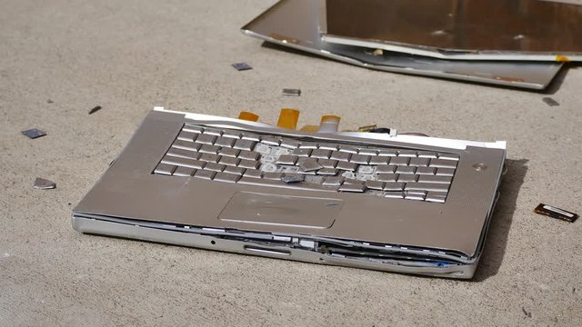 A laptop being smashed to bits with a hammer