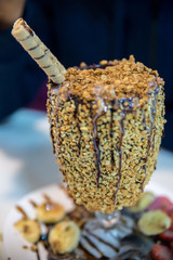 Delicious ice cream with peanuts and chocolate covered glass with wafer roll sticks on top