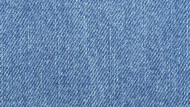 Jeans fabric plain surface background. Denim textile texture tracking. Top view. Slider shot