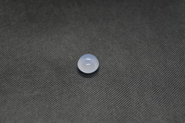 Natural Chalcedony in a shape of cobochon on black fabric background.