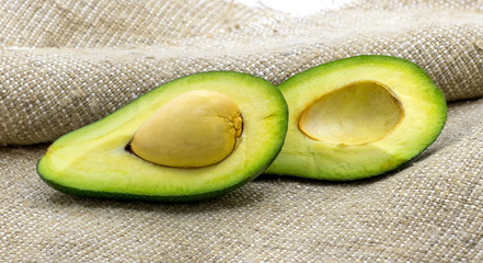 Two halves of avocado on burlap, useful food with a high content of vitamins_