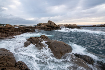 Fototapeta na wymiar Landscape of a rocky beach with cloudy sky, silk effect, long exposure in Cangas, O Grove, Aldán, Vigo, Pontevedra, Galicia, Spain.