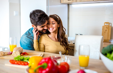 Obraz na płótnie Canvas Young cute Caucasian couple embracing with love and affection during brunch in the kitchen.