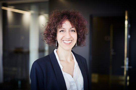 Portrait of smiling female legal professional with curly hair at office - Powered by Adobe