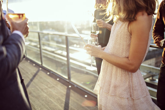 Midsection of business people enjoying drinks after work on office terrace