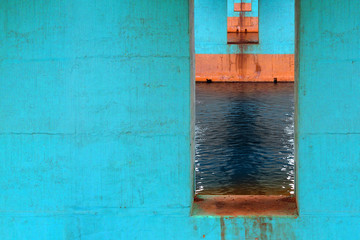 Urban architecture, under the bridge. Turquoise bridge piers extending into the distance