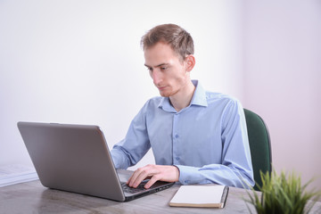 Fototapeta na wymiar Portrait of young business man sitting at his desk desktop laptop technology in the office.Internet marketing, finance, business concept
